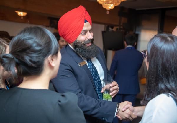 An employer talking with two students at an MBA networking event