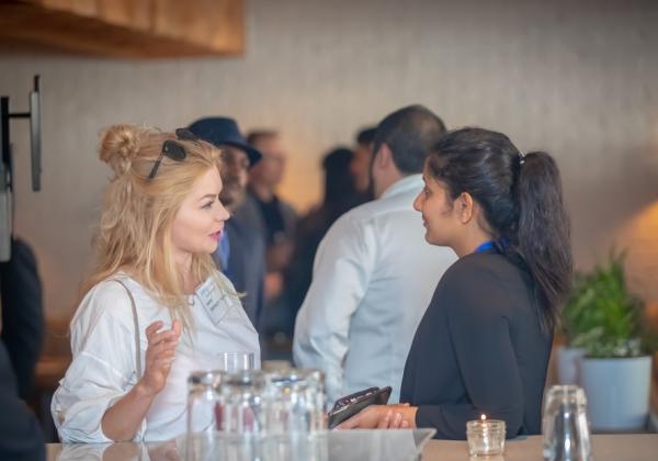 A female student and femaile employer talking at a networking event