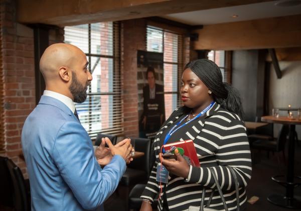 A female student speaking with a male employer