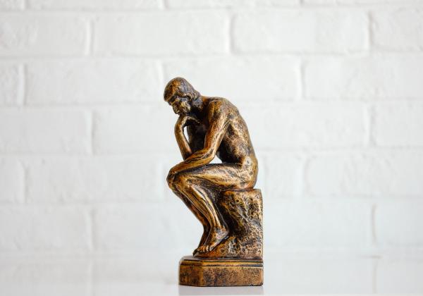 A statue of a man sitting and thinking