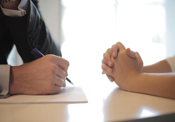 Hands of two people sitting at a table talking