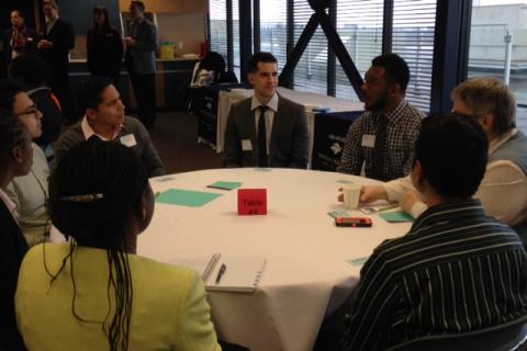 A group of students and employers talking at a table during the LMRT